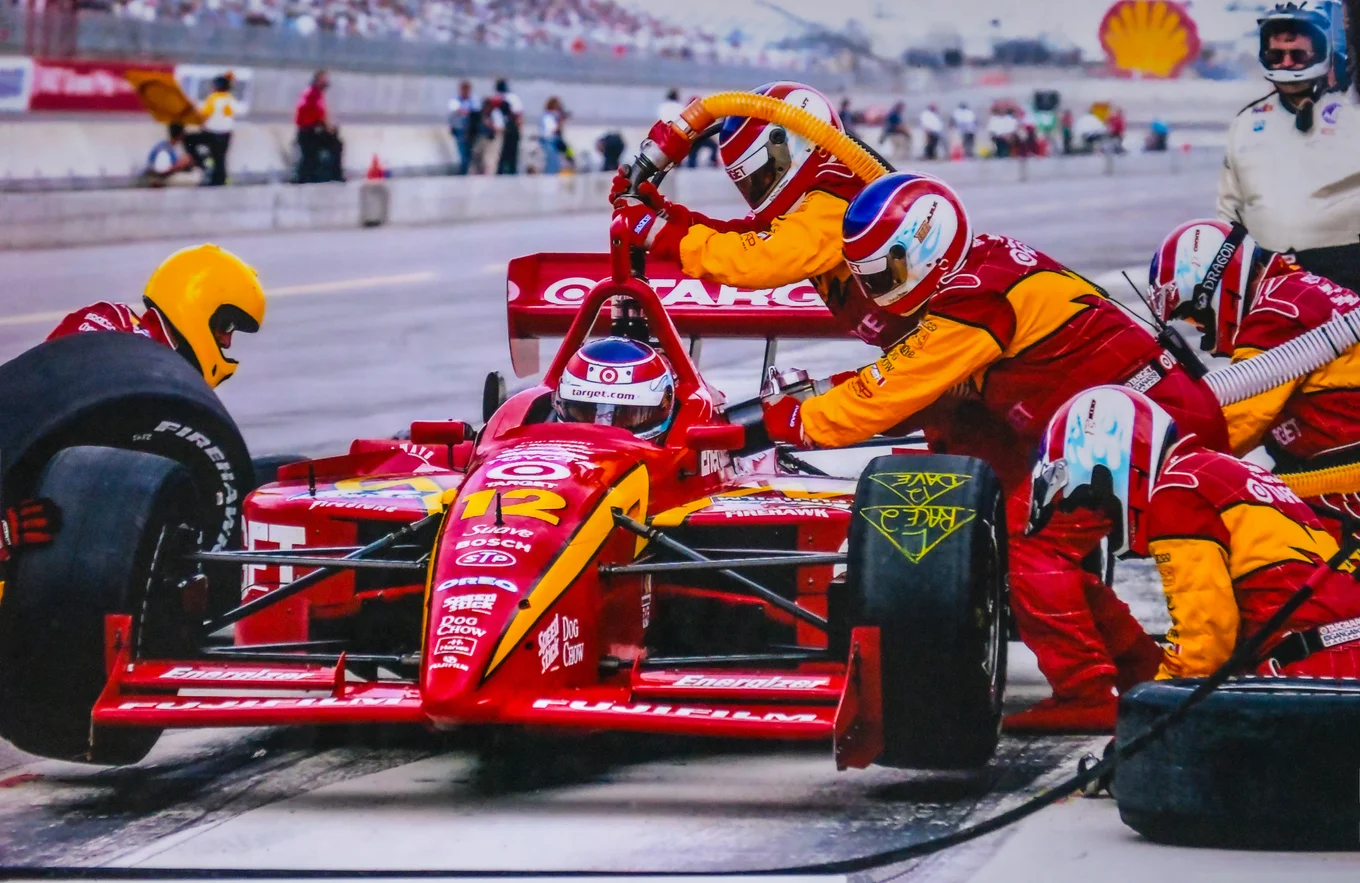 Race car with pit crew, helmets, and equipment.